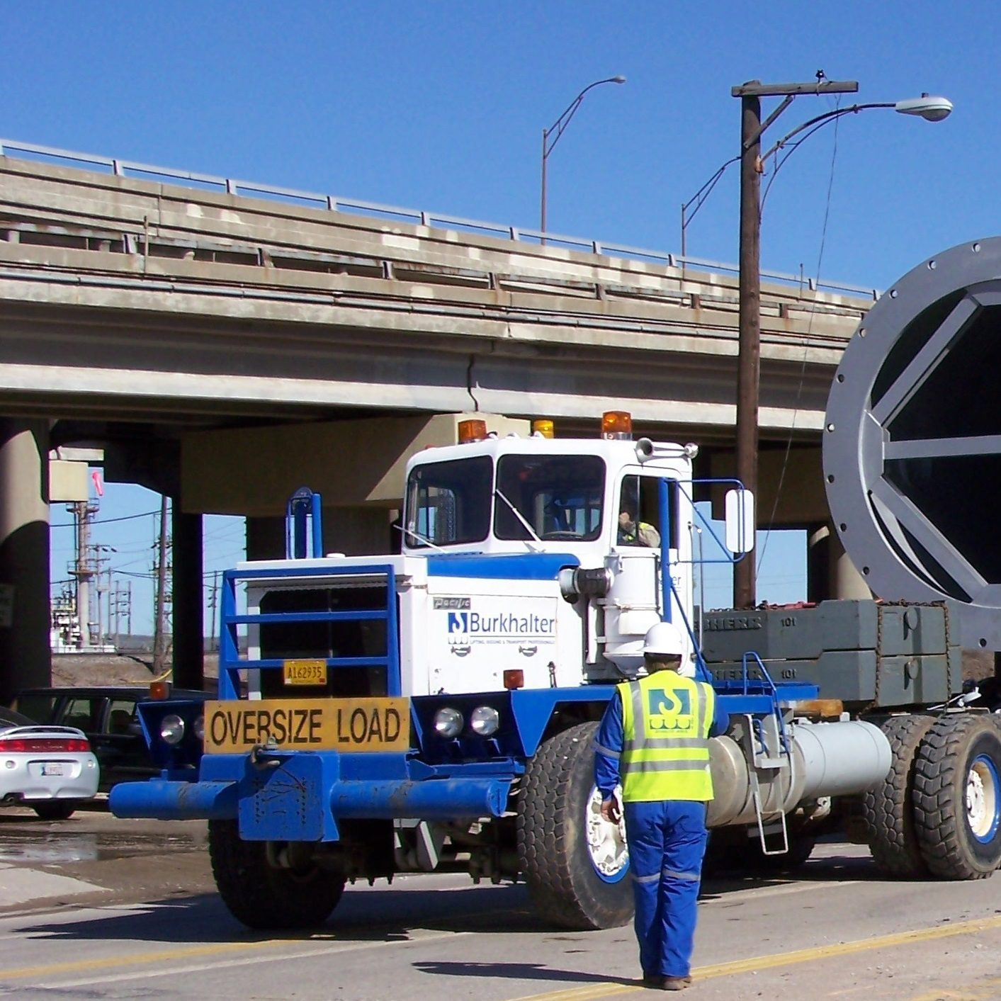 Man walking up to a oversize load semi-truck on a road