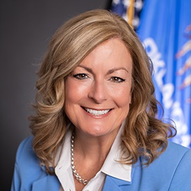 Headshot of Kim David in front of US and Oklahoma flags