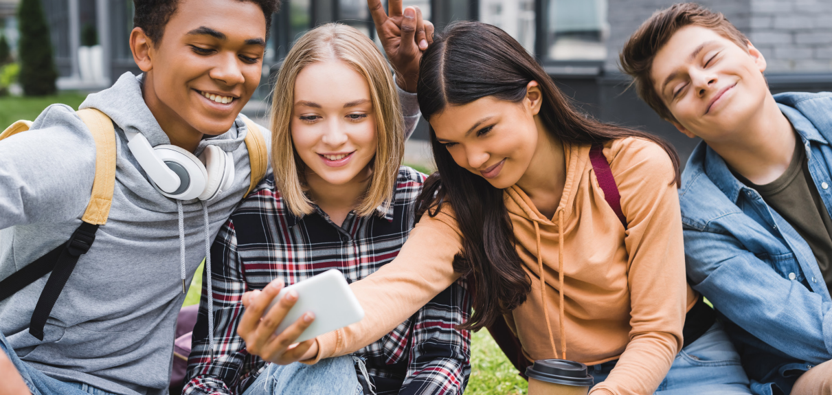 A group of four teens poses for a selfie.