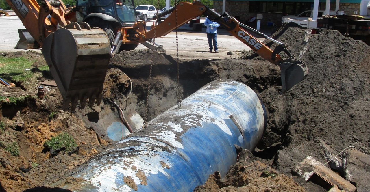Heavy equipment removing old petroleum storage tank from underground