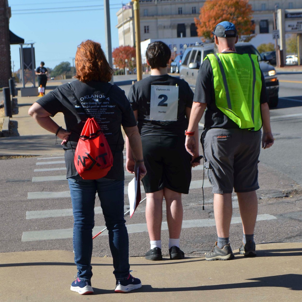 A contestant with a cane and a judge and a man at a stop light.