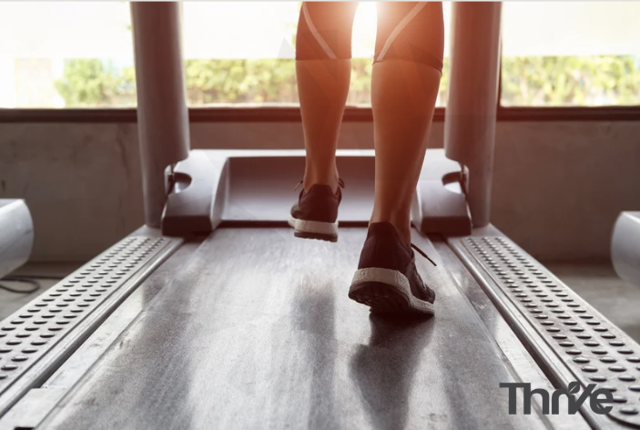 woman on a tread mill with the sun shining on her legs
